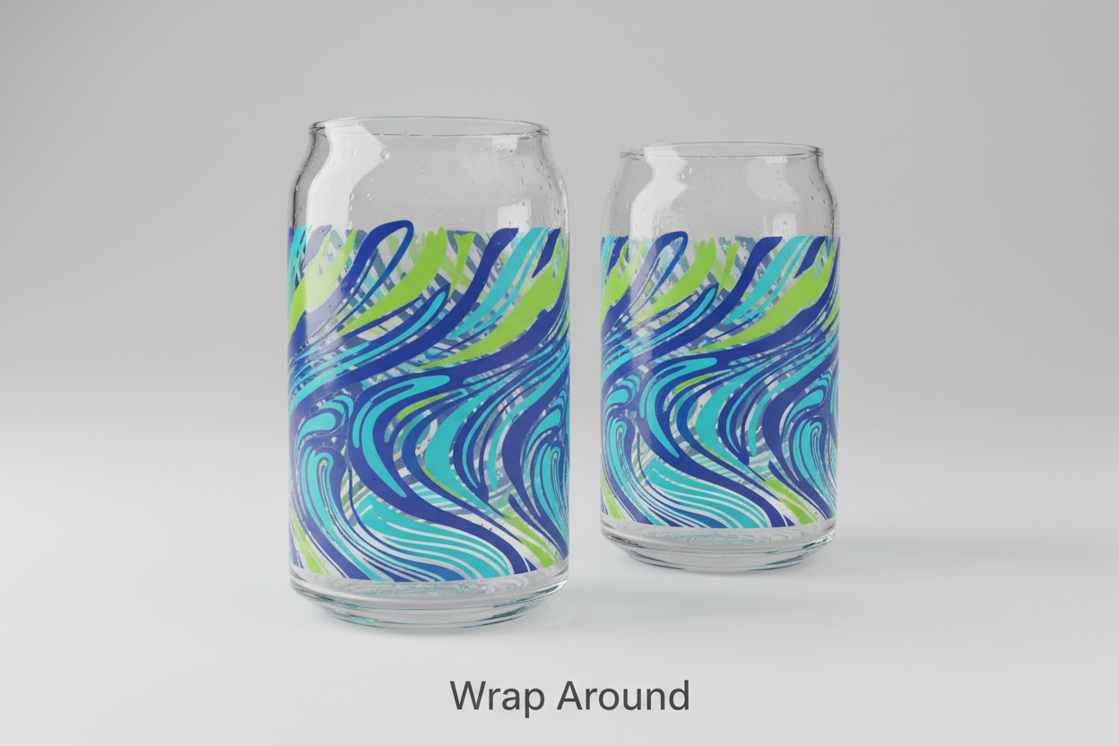 Two 16oz beer can glasses on a simple, neutral studio background. Angle the first glass to show a seamless wraparound graphic that curves across the entire glass surface, and place the second glass slightly behind or beside it to reinforce the wraparound effect. Use a long, continuous placeholder design that clearly wraps around the glass. At the bottom of the image, add clean text that says “Wrap Around”. Use smooth lighting with natural glass shine and reflections.
